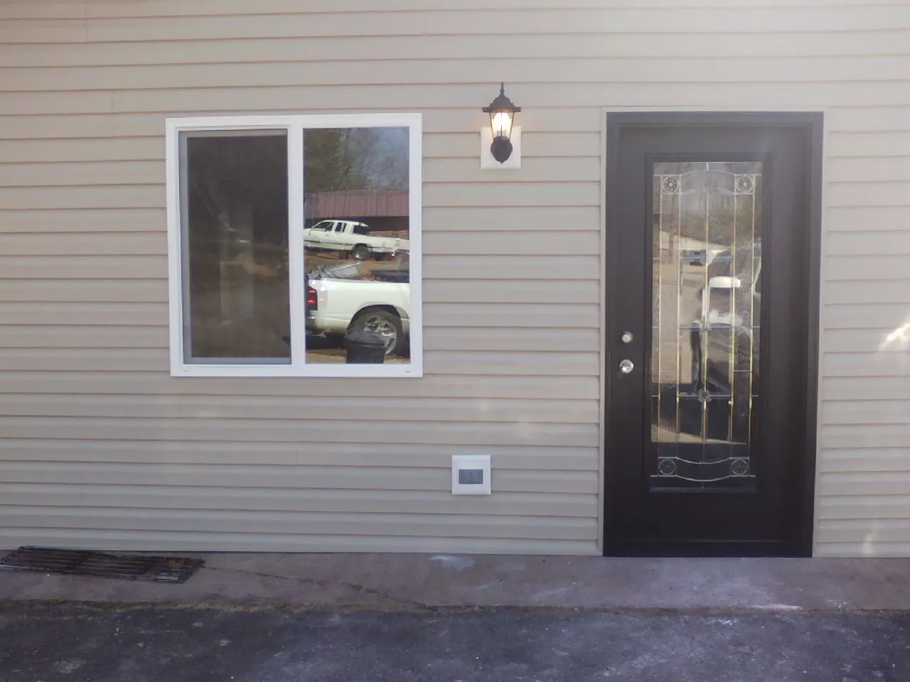 New siding, window and entry door on the side of an addition in Millbrook