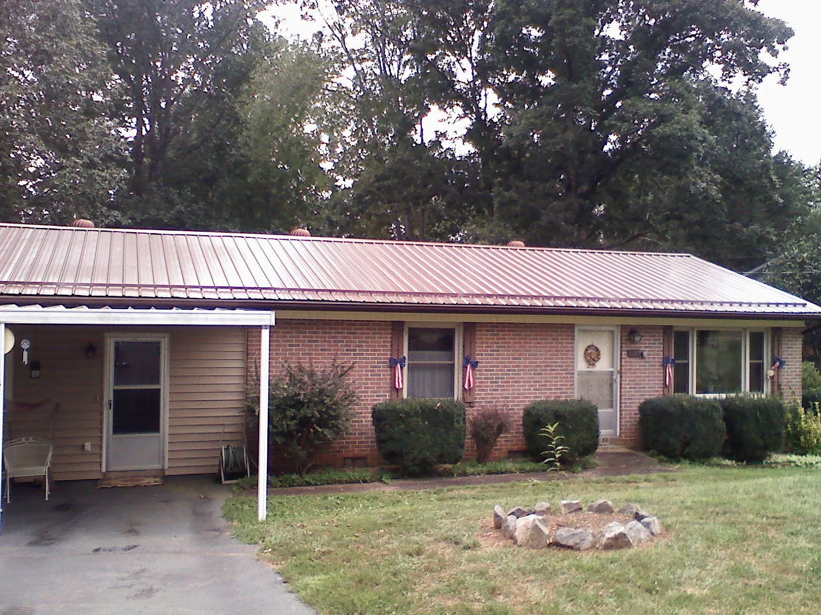 Bronze metal roof and carport on a brick ranch home — Roof Repair work by our crew in Millbrook